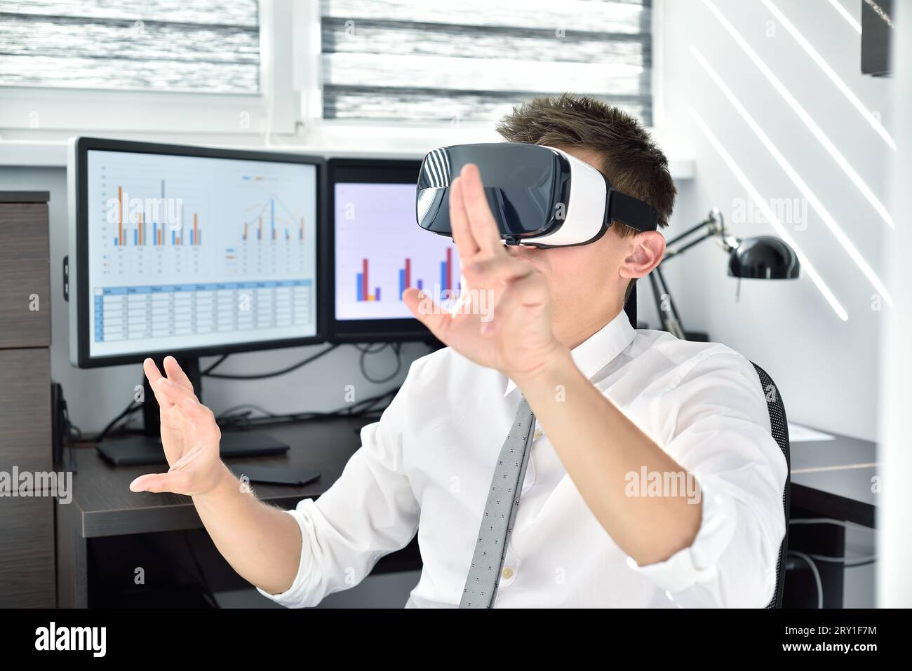 Manager avec casque VR travaillant sur un rapport d'affaires virtuel. Concept de travail interactif Banque D'Images