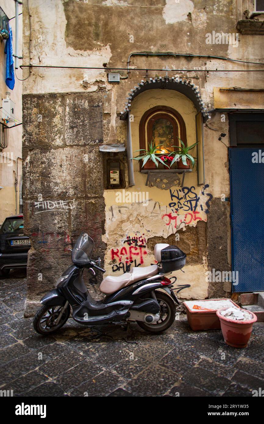 Italie, Campanie, Naples, via Francesco Saverio Carciulo, scooter garé sous une niche abritant une image religieuse, novembre 2021. Banque D'Images