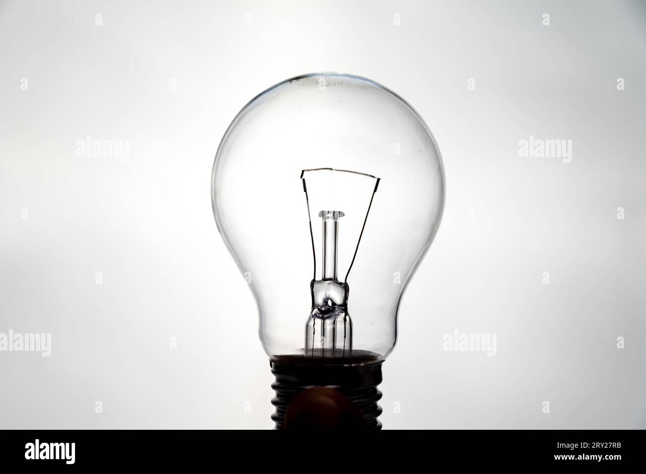 Ampoule incandescente, photographiée contre la lumière, qui semble allumée. Électricité et sources d'énergie renouvelables. Banque D'Images
