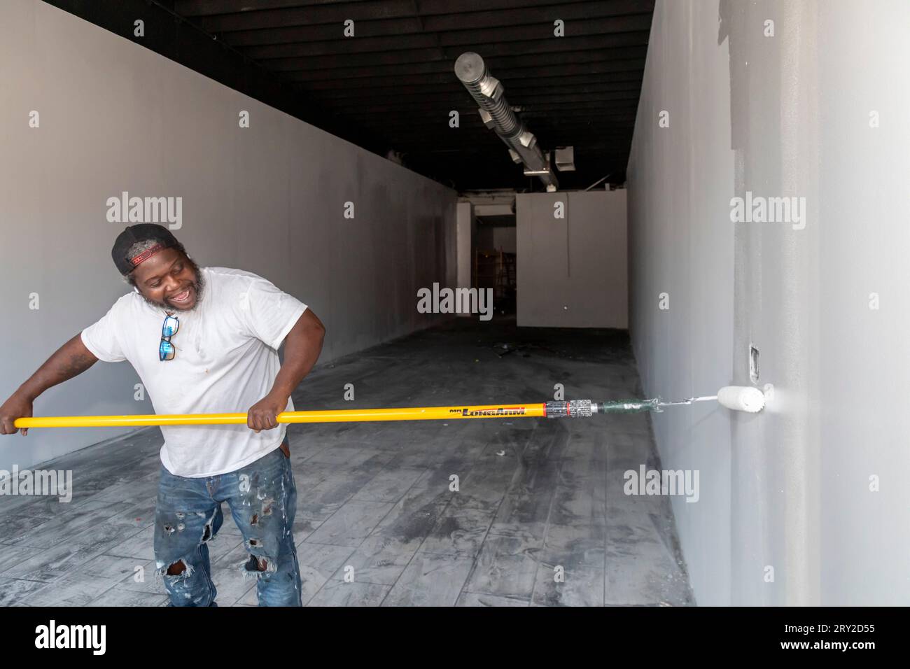 Detroit, Michigan - Un travailleur repeint un espace de vente après que le magasin a été gravement endommagé par un incendie déclenché par une bougie allumée. Banque D'Images