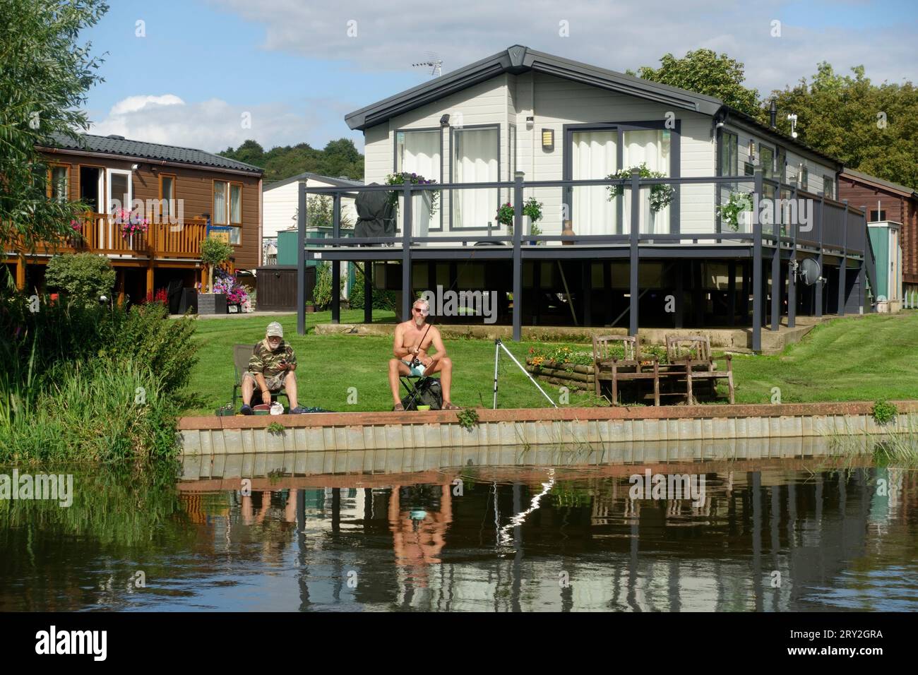 Deux hommes pêchant grossièrement dans la rivière Avon en dehors du site de caravane statique Evesham UK Banque D'Images