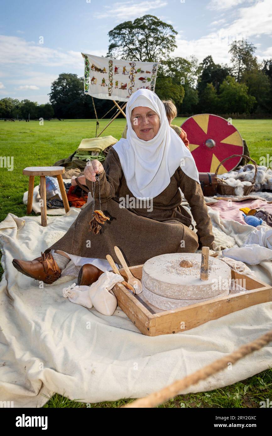 Viking Woman broie de l'eau en farine tout en célébrant les 1100 ans de l'ancienne «cyty» de Thelwall et tient du pain séché Banque D'Images