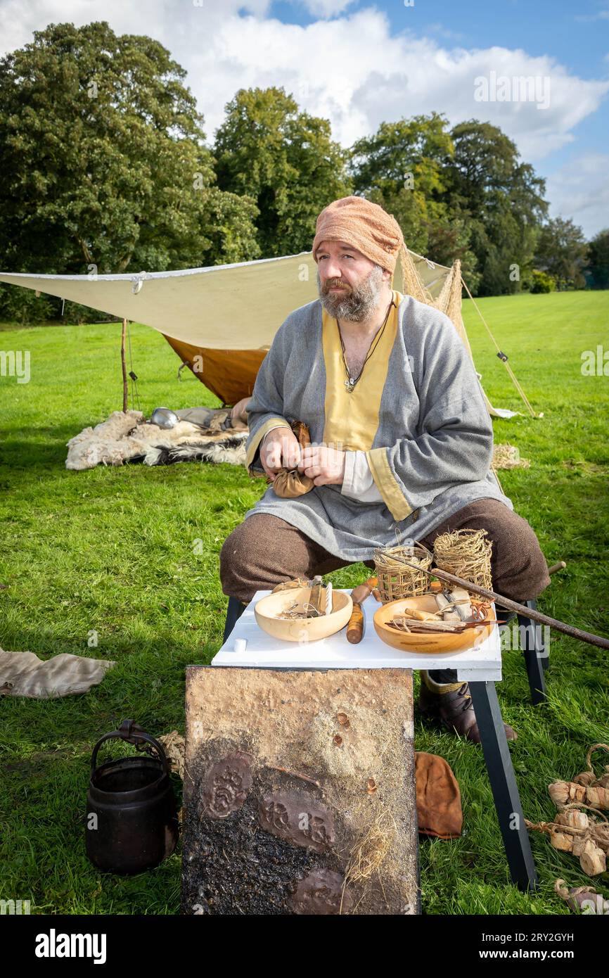 Viking mâle retire les outils de fabrication de filet d'une pochette en cuir tout en célébrant les 1100 ans de l'ancienne «cyty» de Thelwall Banque D'Images