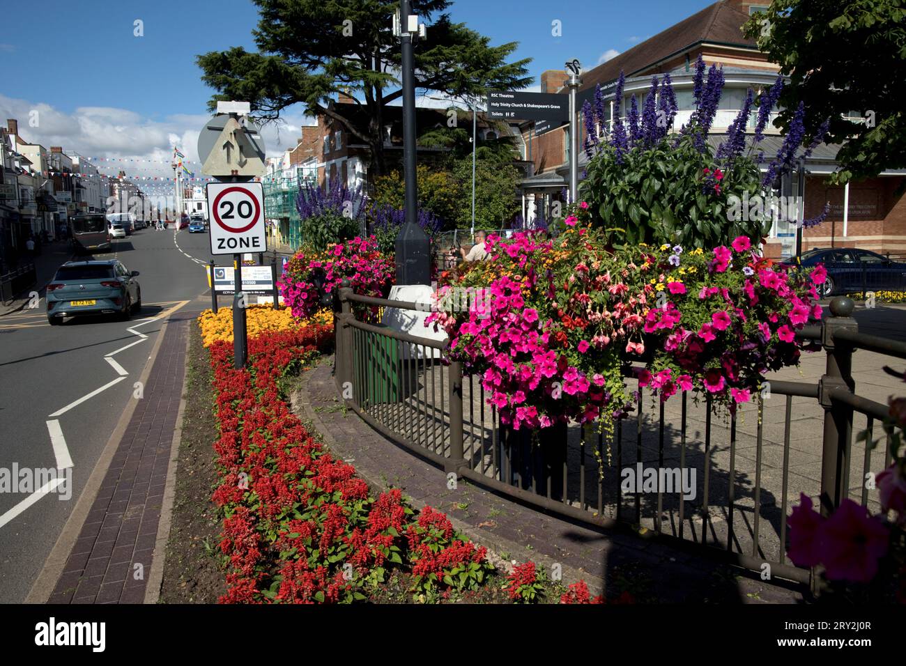 Panneau de limitation de vitesse à 20 km/h, à côté de superbes expositions florales publiques célébrant Stratford in Bloom et inspirées par Plantscape sur l'exposition publique du Banque D'Images