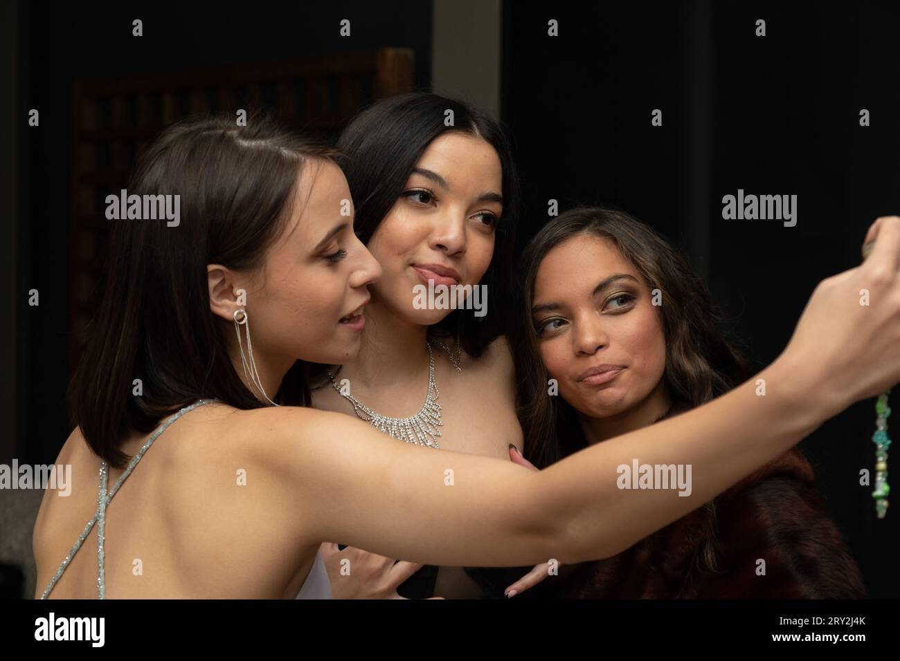 Dans un instantané de bal rapproché, trois jeunes femmes prennent une pose, capturant un moment joyeux alors qu'elles prennent un selfie ensemble Banque D'Images
