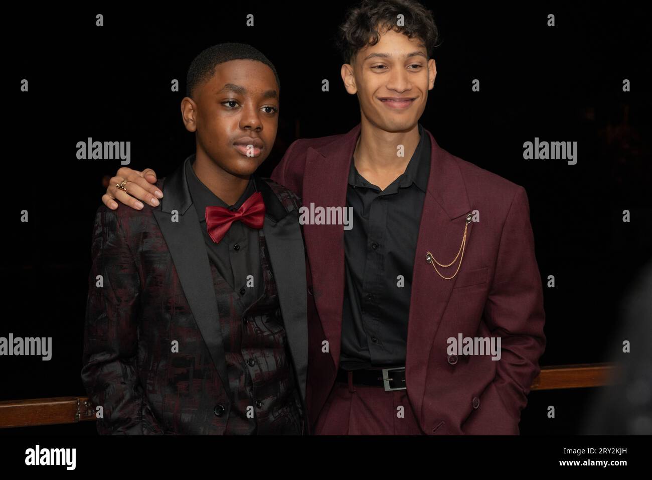 Dans un gros plan, deux jeunes hommes multiraciaux élégants du bal de promo respirent confiance et camaraderie alors qu'ils prennent une pose Banque D'Images