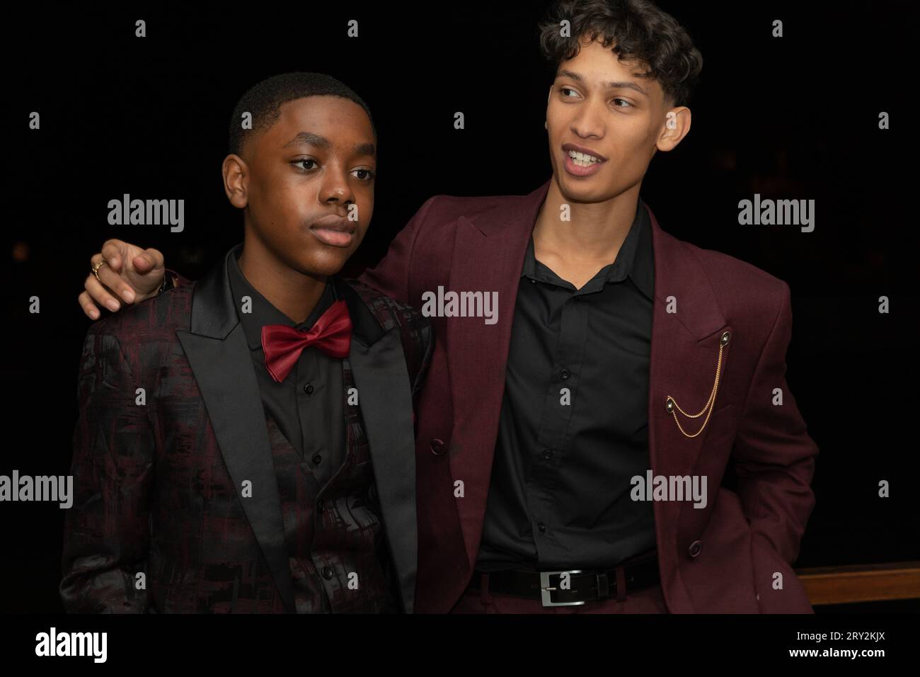 Dans un gros plan, deux jeunes hommes multiraciaux élégants du bal de promo respirent confiance et camaraderie alors qu'ils prennent une pose Banque D'Images