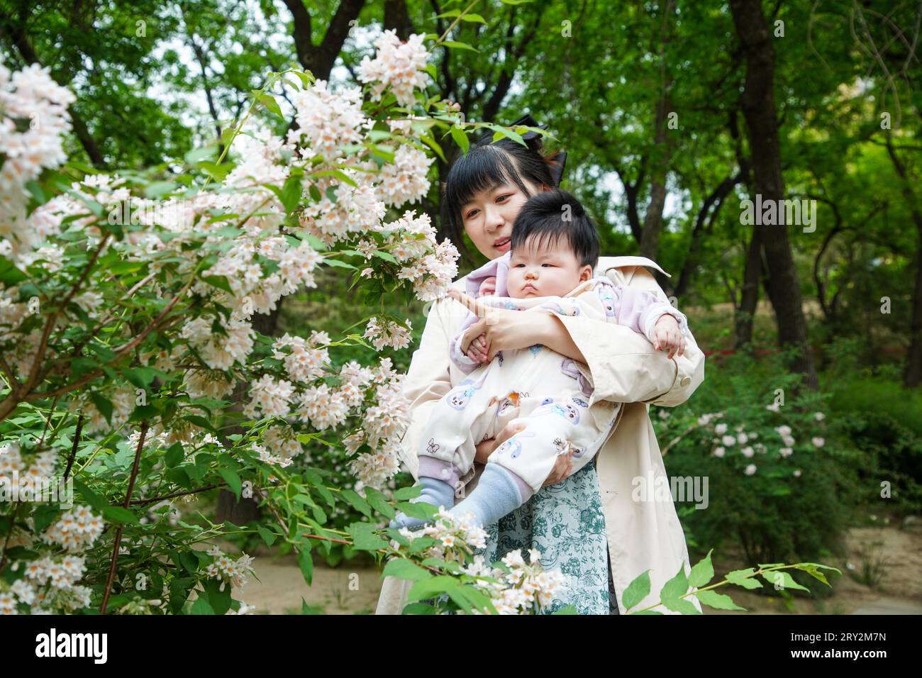 Pékin, Chine - 6 mai 2023 : une femme tenant un bébé joue dans le parc. Banque D'Images