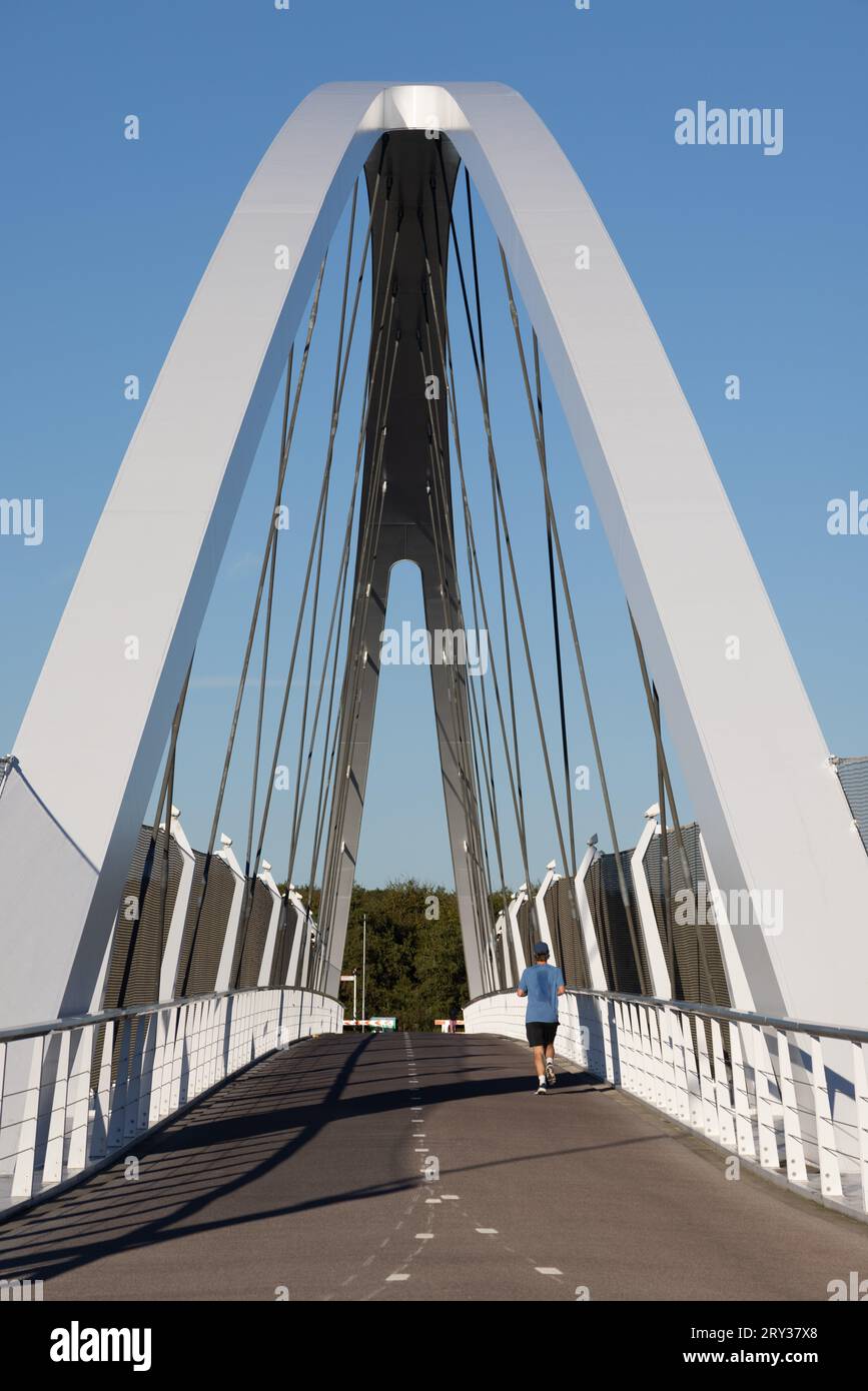 Coureur en t-shirt en sueur sur le pont cycliste Tegenbosch sur l'autoroute A2 / autoroute N2 à Eindhoven, aux pays-Bas Banque D'Images