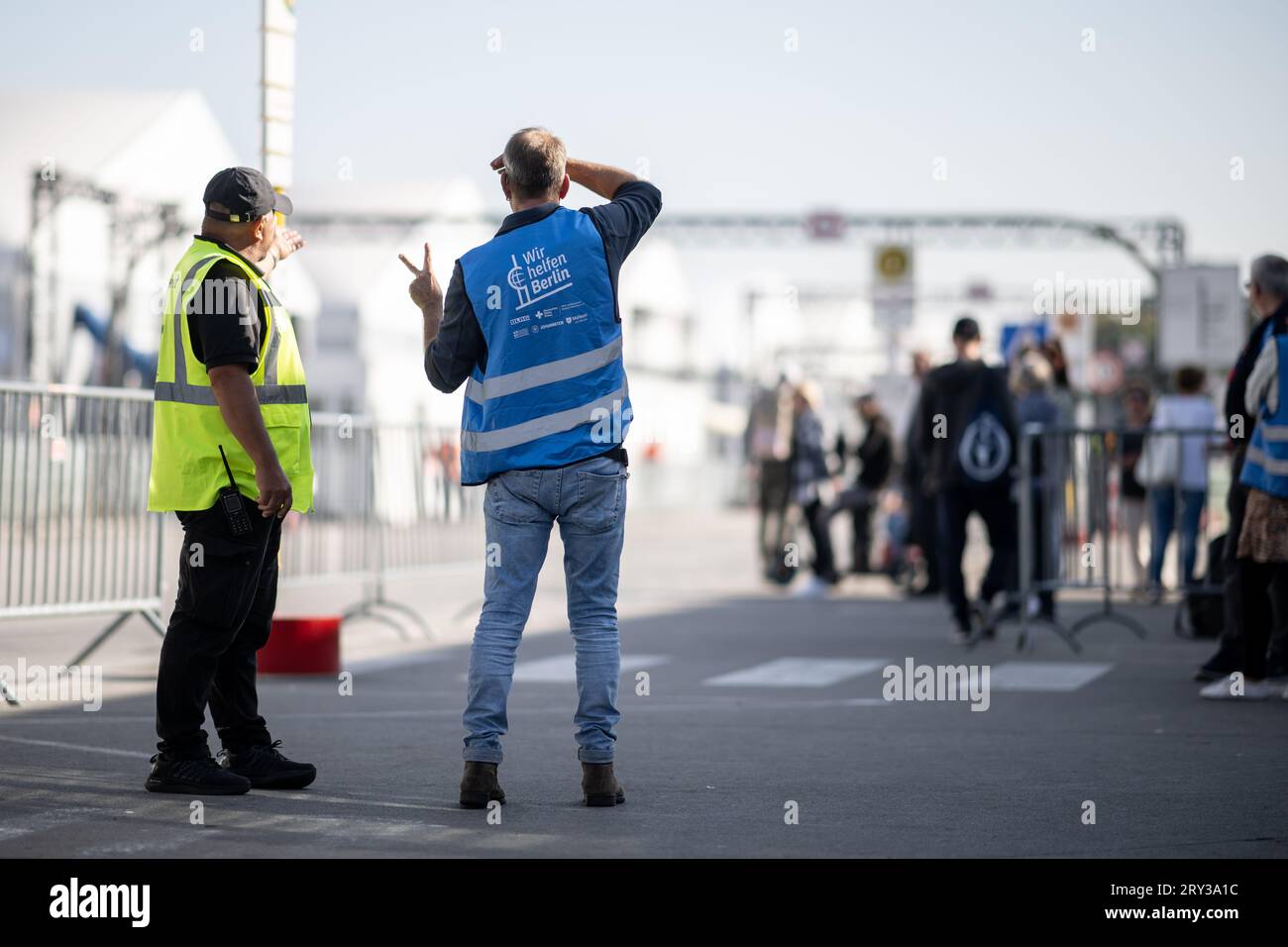 Berlin, Allemagne. 28 septembre 2023. Des aides et des forces de sécurité se tiennent dans l'abri d'urgence pour réfugiés de l'ancien aéroport de Tegel. Crédit : Sebastian Gollnow/dpa/Alamy Live News Banque D'Images