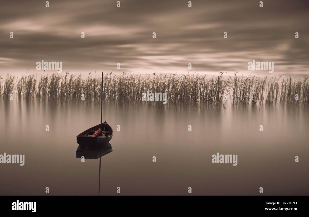 Matin brumeux avec le bateau sur un lac Banque D'Images