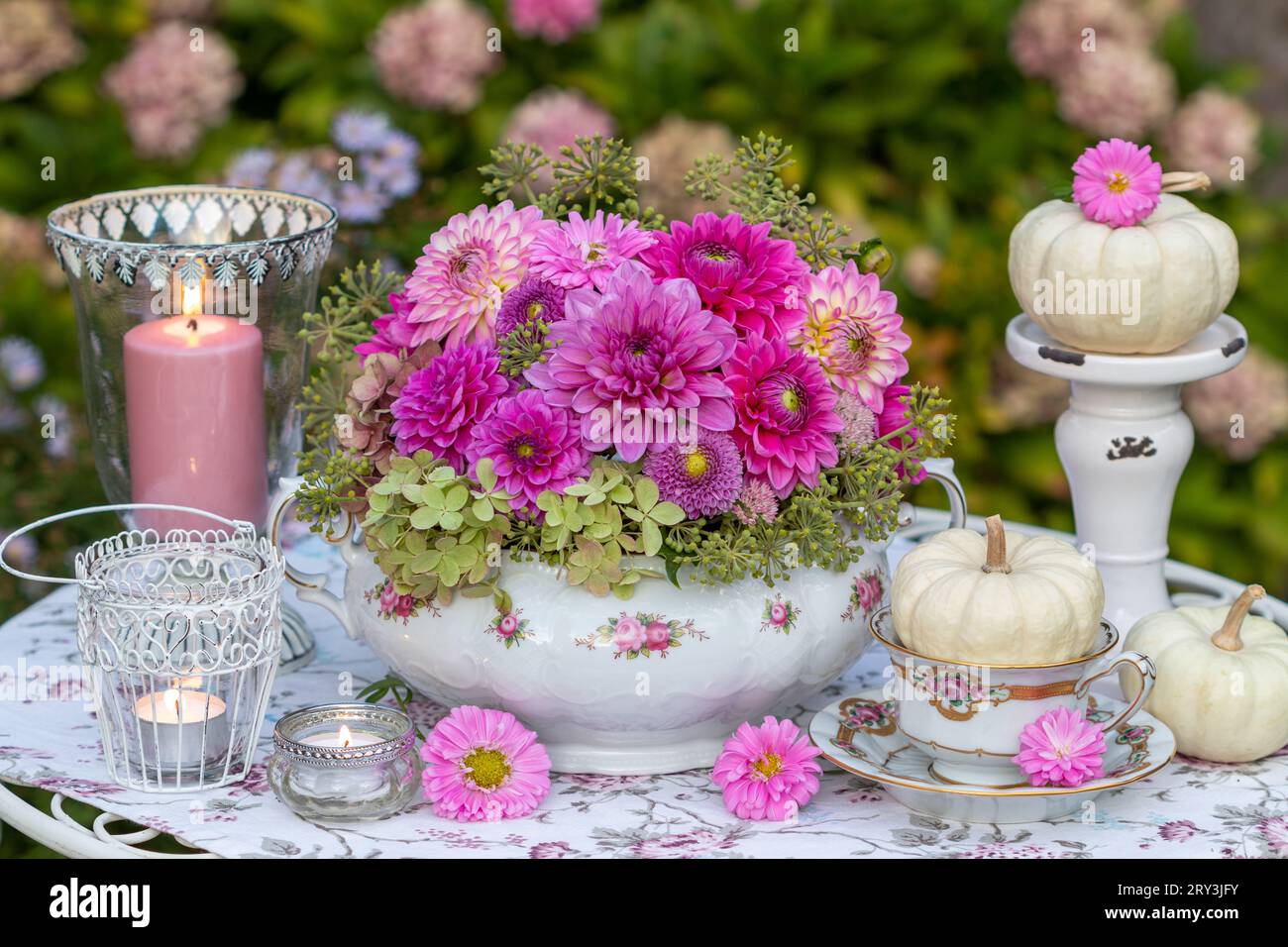 arrangement floral romantique de dahlias roses dans une soupe vintage, citrouilles blanches et lanternes de table Banque D'Images