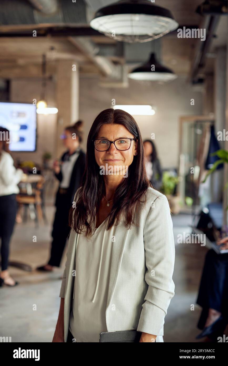 Portrait de femme d'affaires avec de longs cheveux bruns au bureau créatif Banque D'Images