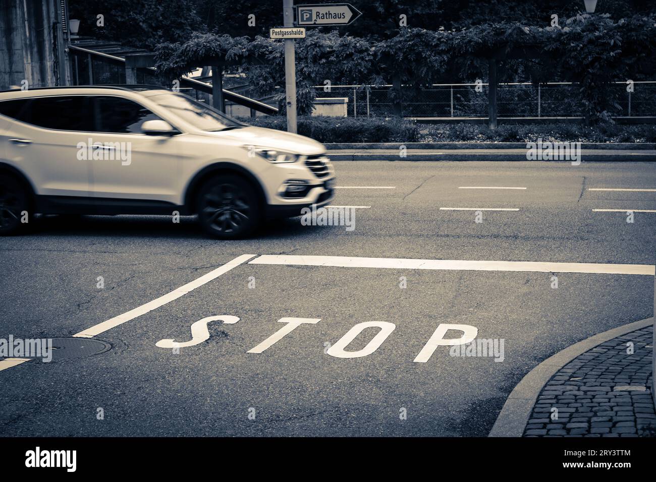 Panneau de signalisation à Berne, Suisse. Image capturée signe d'arrêt avec la conduite de la voiture sur la route en arrière-plan. Banque D'Images