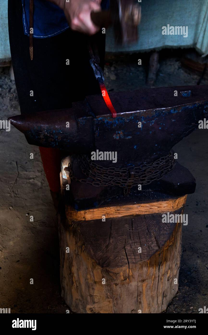 Forgeron travaillant le métal avec marteau sur l'enclume dans la forge. Banque D'Images Forgeron travaillant le métal avec marteau sur l'enclume dans la forge. Banque D'Images