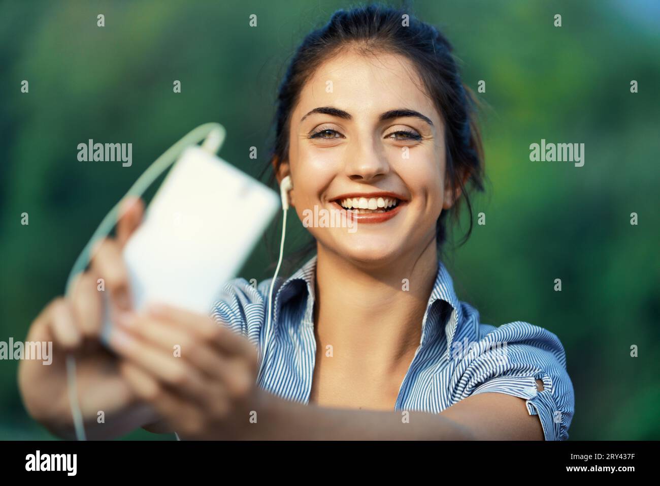 Embrassant la technologie à l'extérieur, la jeune femme utilise le smartphone pour le plaisir, l'auto-promotion, le marketing d'influence, la création de contenu et de vidéo, assurant le produit Banque D'Images