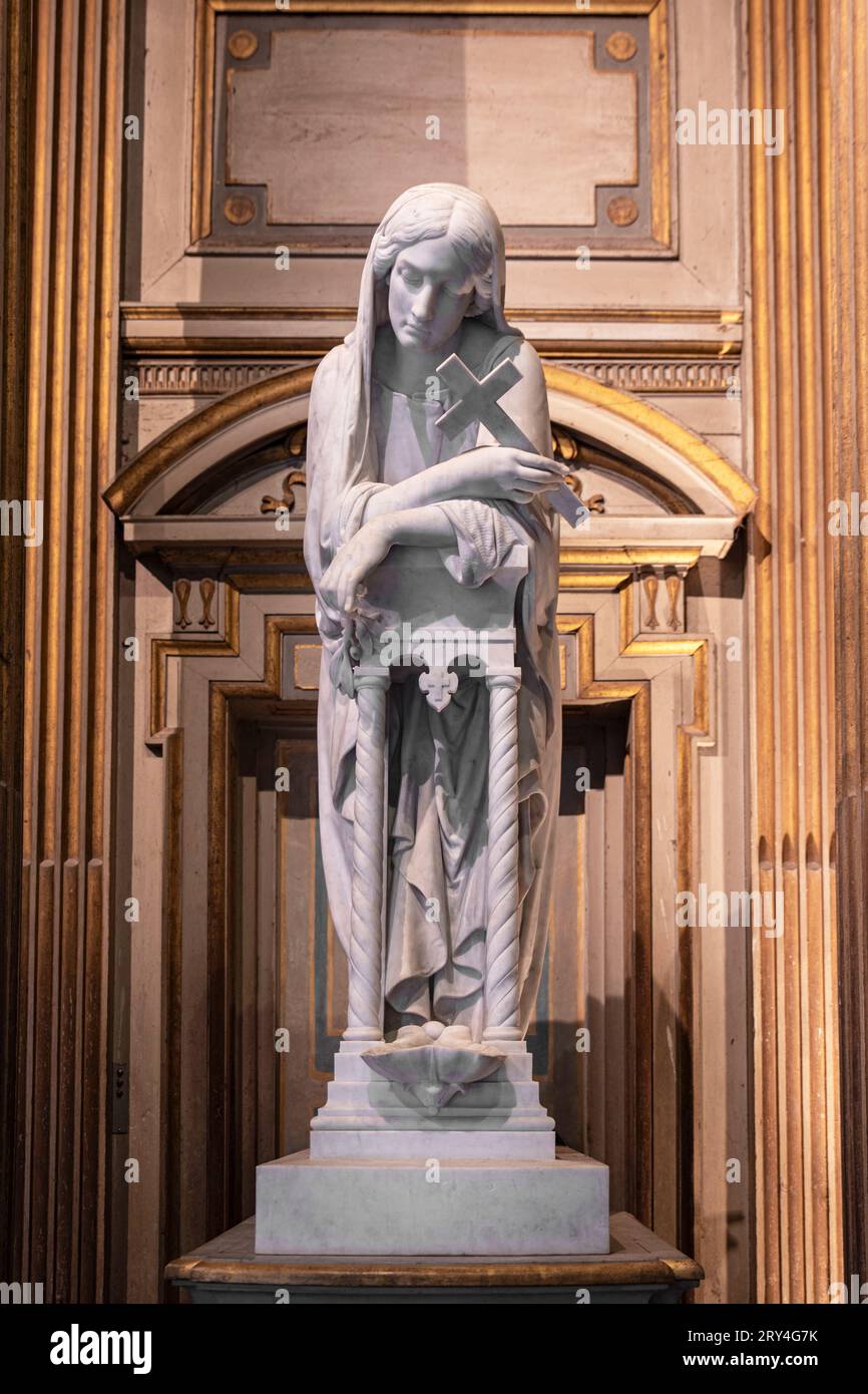 Statue d'une femme priant avec une croix dans les mains Banque D'Images