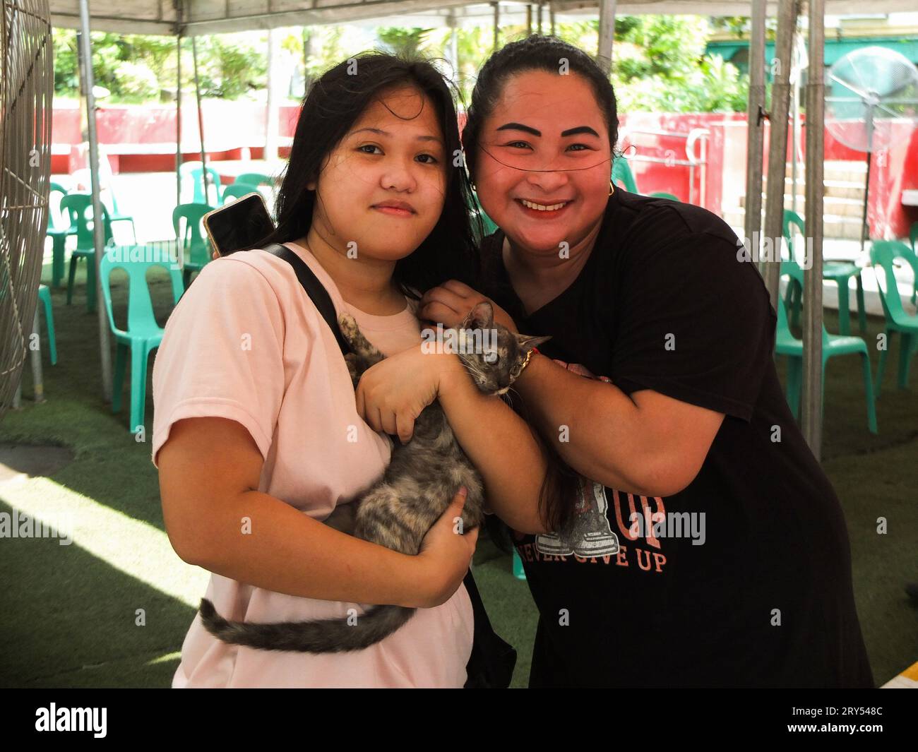 Navotas, Philippines. 28 septembre 2023. Deux dames posent pour une photo avec leur chat. Dans le cadre de la célébration de la Journée mondiale de la rage, le gouvernement de la ville de Navotas dirigé par le bureau de l'agriculture de la ville de Navotas, a procédé à la vaccination gratuite des chiens et des chats et à l'enregistrement des animaux de compagnie. Ils ont également donné gratuitement de la nourriture pour animaux de compagnie à ceux qui ont participé au programme. Crédit : SOPA Images Limited/Alamy Live News Banque D'Images