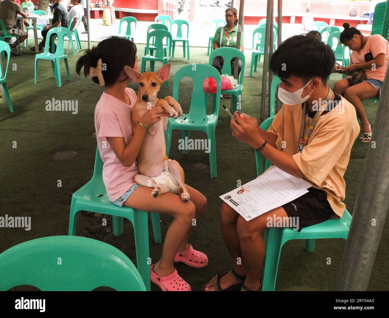 Navotas, Philippines. 28 septembre 2023. Un jeune couple a enregistré son chien pour la vaccination. Dans le cadre de la célébration de la Journée mondiale de la rage, le gouvernement de la ville de Navotas dirigé par le bureau de l'agriculture de la ville de Navotas, a procédé à la vaccination gratuite des chiens et des chats et à l'enregistrement des animaux de compagnie. Ils ont également donné gratuitement de la nourriture pour animaux de compagnie à ceux qui ont participé au programme. Crédit : SOPA Images Limited/Alamy Live News Banque D'Images