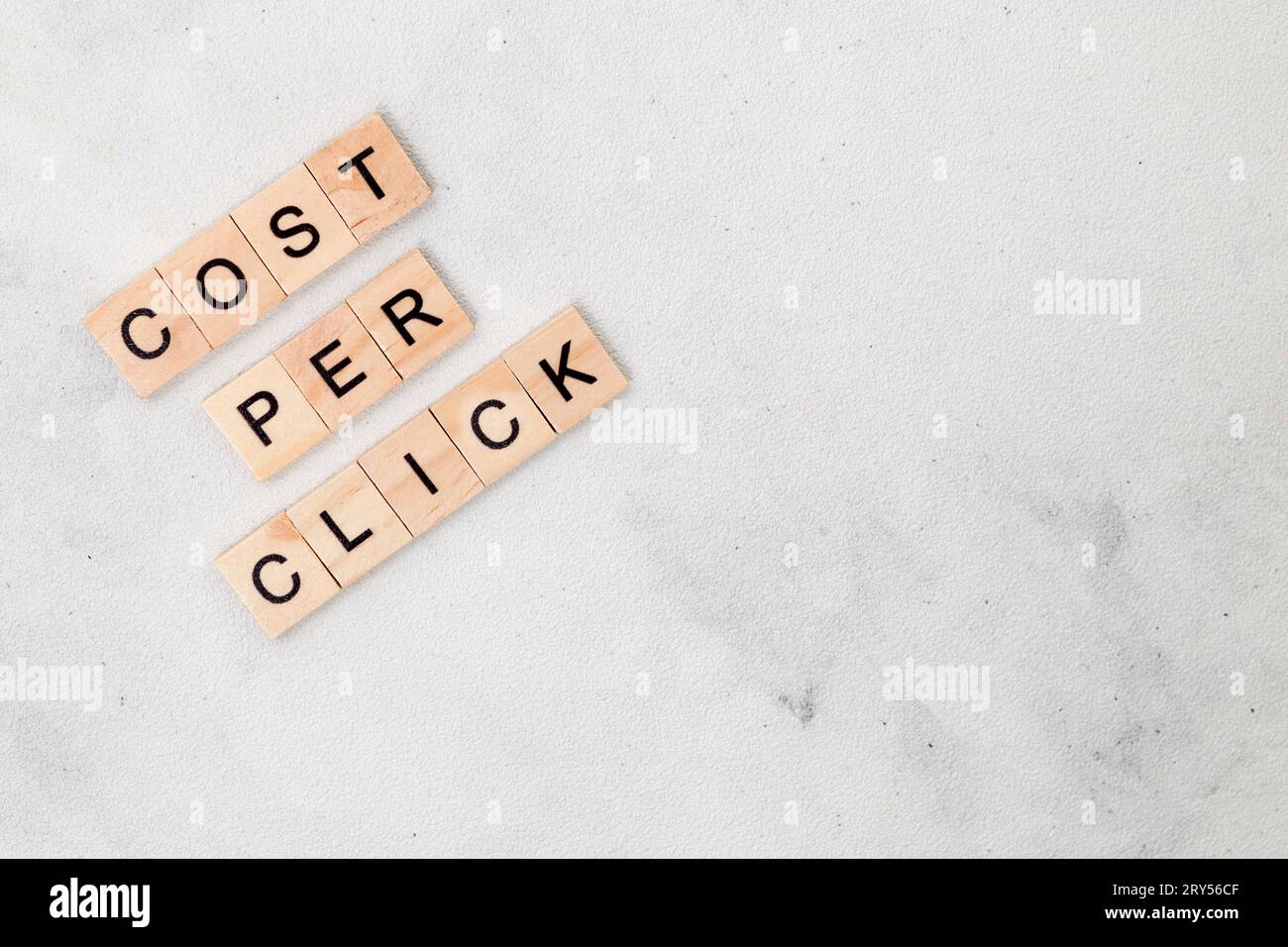 Vue de dessus du coût par mot de clic sur bloc de lettre cube en bois sur fond blanc. Concept commercial Banque D'Images