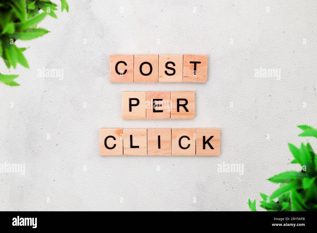 Vue de dessus du coût par mot de clic sur bloc de lettre cube en bois sur fond blanc. Concept commercial Banque D'Images