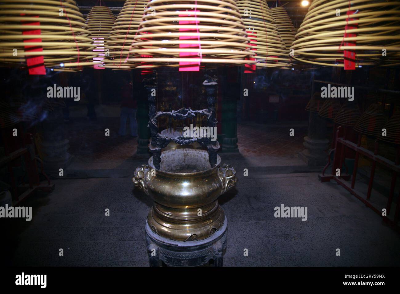 Scène à l'intérieur du temple taoïste Man Mo avec des bâtons de joss et des bobines d'encens en spirale, Hong Kong Banque D'Images