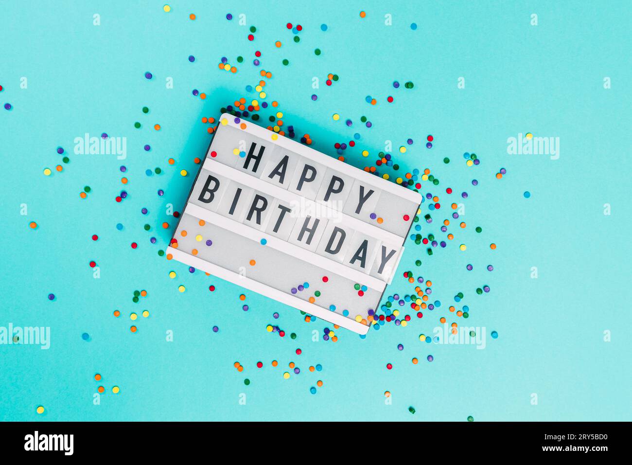 Visionneuse avec texte Joyeux anniversaire et saupoudrages de sucre colorés, vue de dessus Banque D'Images
