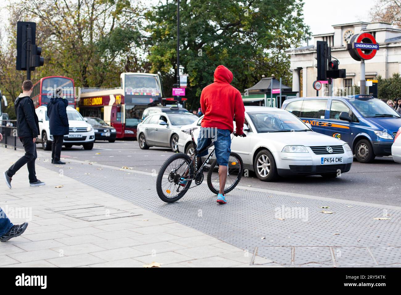 Cycliste traversant la route dans la ville de Londres et plusieurs[les types de transport en une seule photo 2013 (vélo/voiture/bus/minibus/van/tube/marche) Banque D'Images