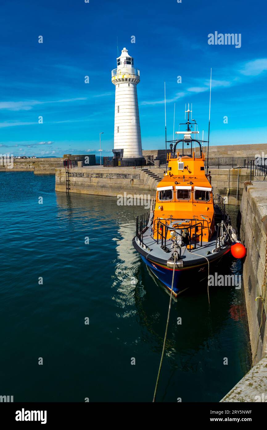 Donaghadee, comté de Down, Irlande du Nord Mars 09 2018 - Donaghadee Lifeboat amarré sur le quai et le phare de Donaghadee en arrière-plan Banque D'Images