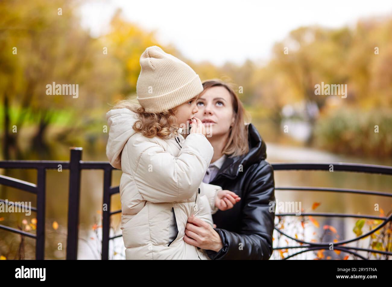 Bonjour octobre. Mère et fille marchent dans le parc de la ville d'automne. Parent et petit enfant s'amusant à l'extérieur Banque D'Images