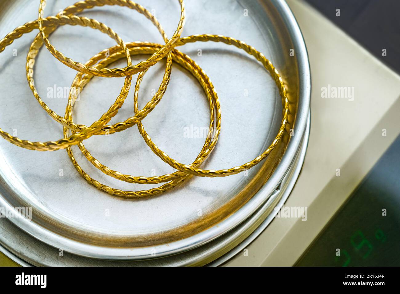 Pile de bracelet torsadé en or turc 24k (24 carat) sur l'échelle du bijoutier de précision Banque D'Images