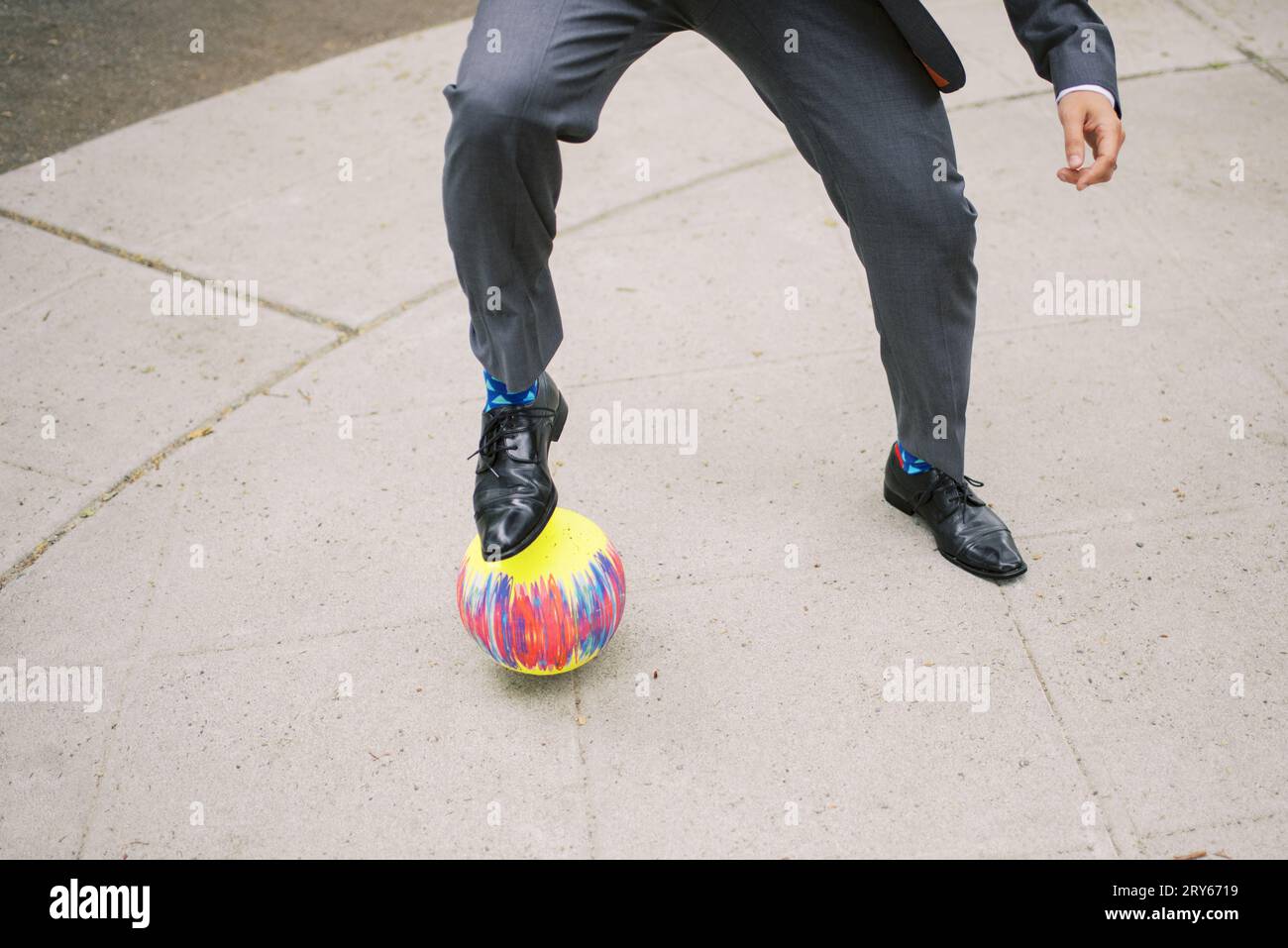 L'homme en costume joue au kickball, tir d'action. Banque D'Images