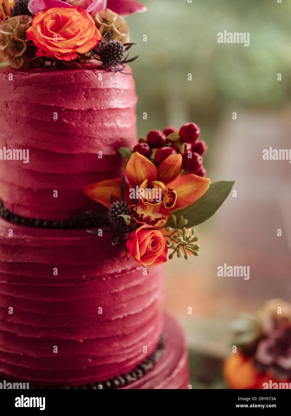 Gâteau à trois niveaux orné de glaçage violet et de fleurs d'automne Banque D'Images