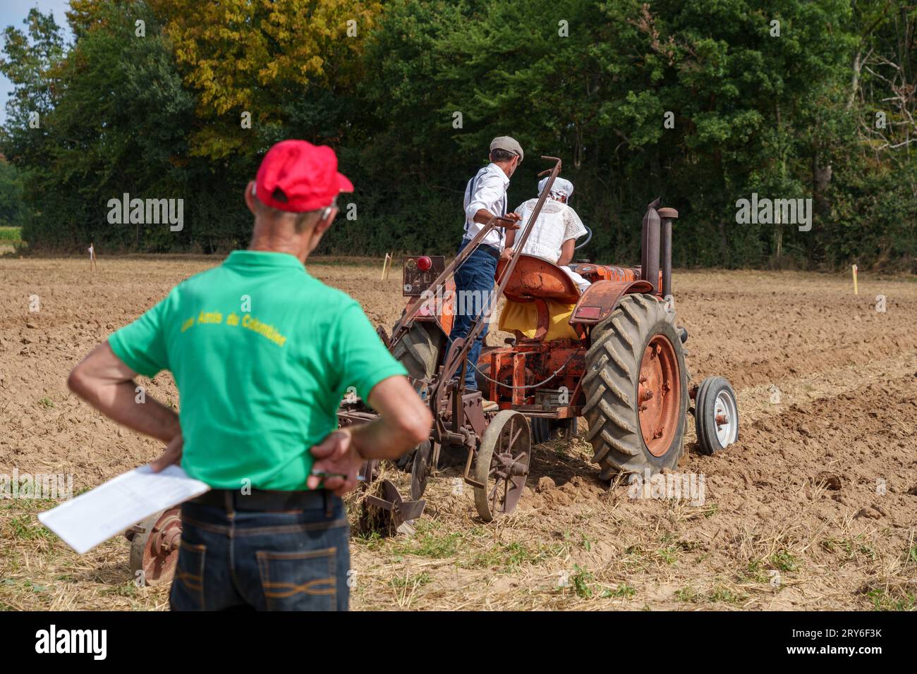 Un juge regardant les concurrents dans une compétition de labour lors d'un festival de récolte. Banque D'Images