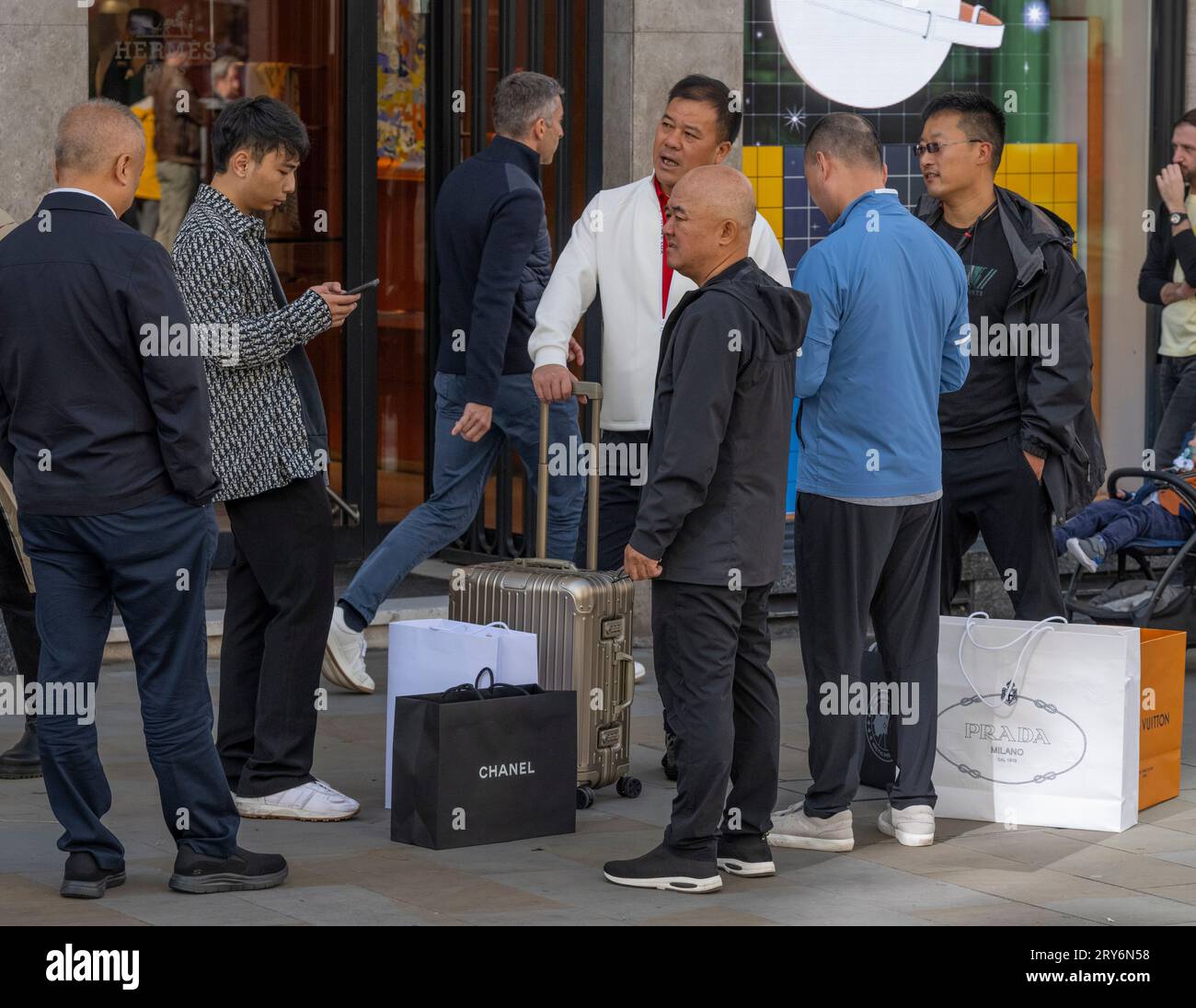 New Bond Street, Londres, Royaume-Uni. 29 septembre 2023. Matinée animée dans la principale rue commerçante de Mayfair. Un groupe d'hommes asiatiques se tient devant le magasin Hermès à New Bond Street, avec des sacs de créateurs d'achats dans les magasins Chanel, Prada et Louis Vuitton. Crédit : Malcolm Park/Alamy Live News Banque D'Images