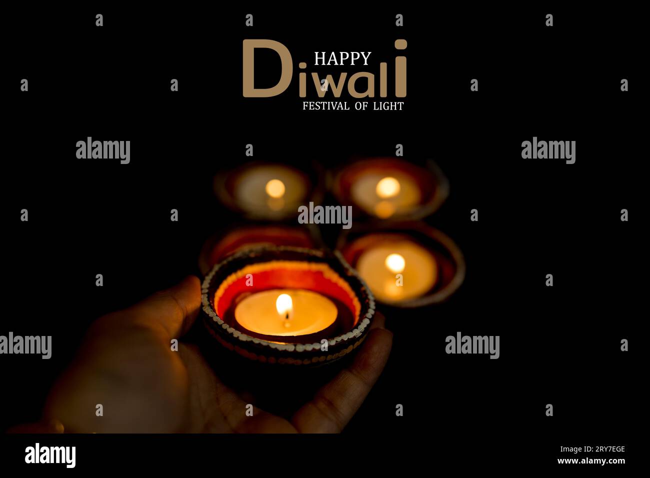 Happy Diwali - femmes mains avec henné tenant la bougie allumée isolé sur fond sombre. Clay Diya lampes allumées pendant Dipavali, festival hindou de lumières ce Banque D'Images