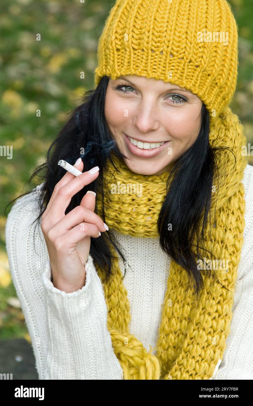 Femme dans le parc avec la cigarette Banque D'Images