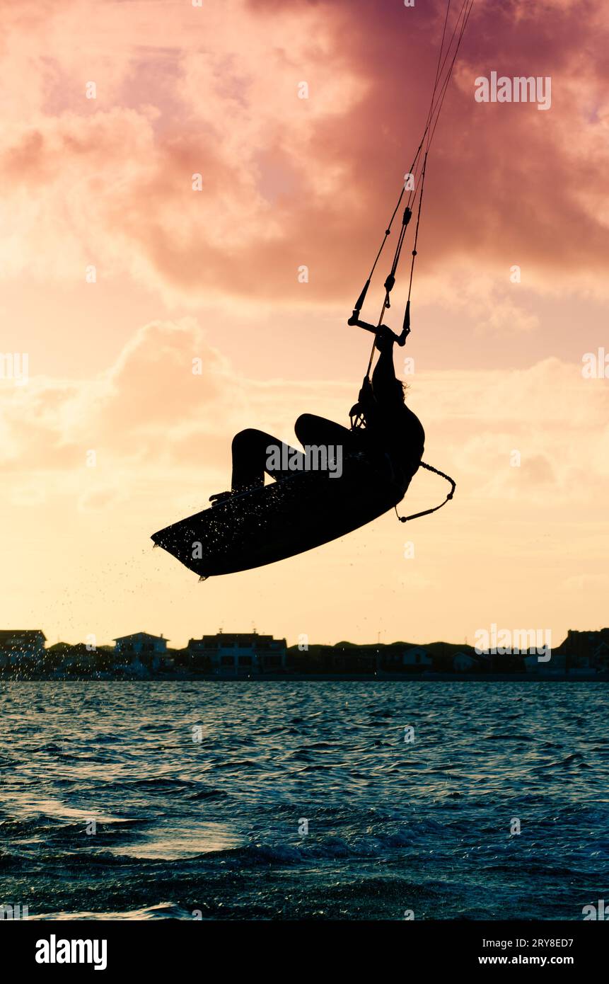 Silhouette d'un kitesurfer volant Banque D'Images