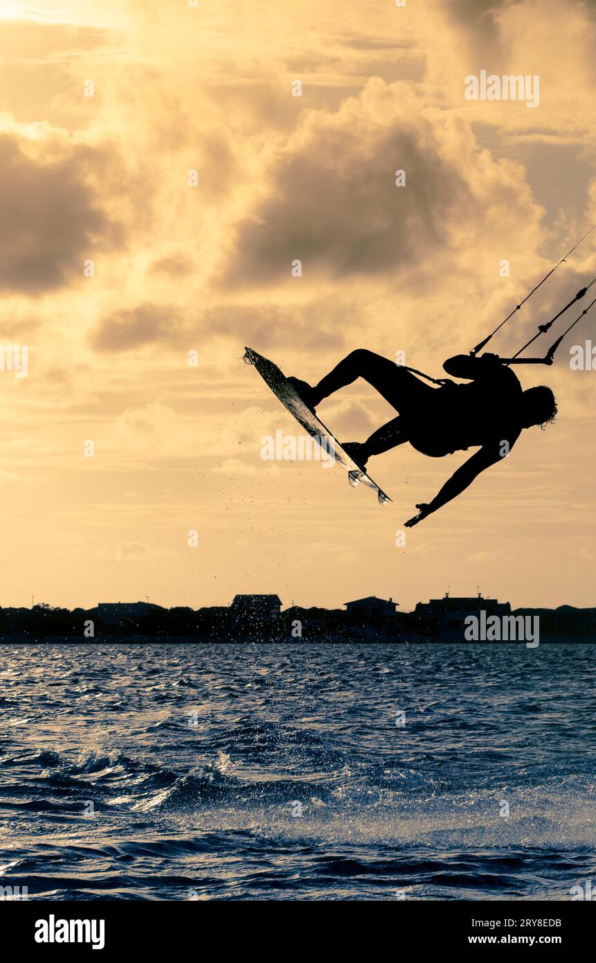 Silhouette d'un kitesurfer volant Banque D'Images