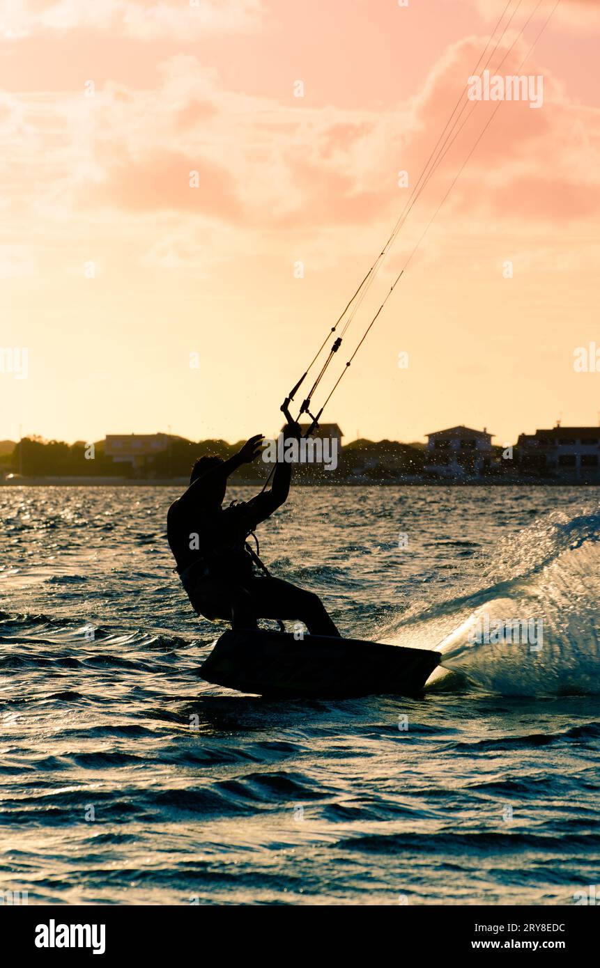 Silhouette d'un kitesurfer volant Banque D'Images
