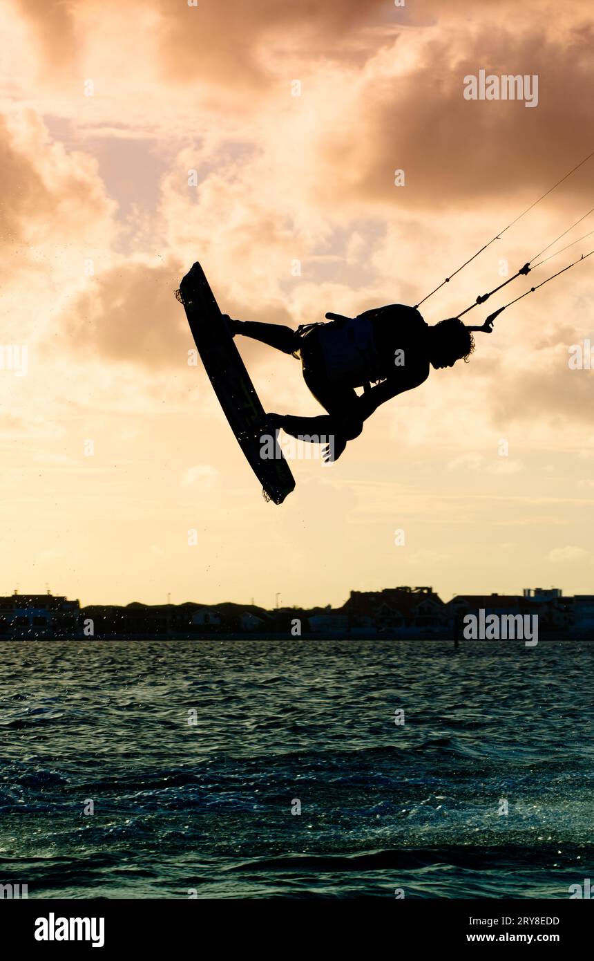 Silhouette d'un kitesurfer volant Banque D'Images