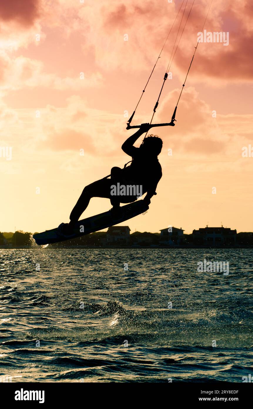 Silhouette d'un kitesurfer volant Banque D'Images