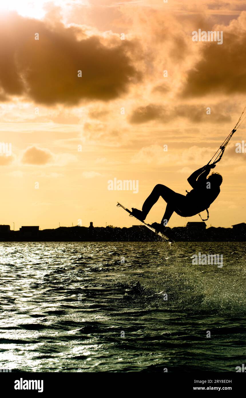 Silhouette d'un kitesurfer volant Banque D'Images