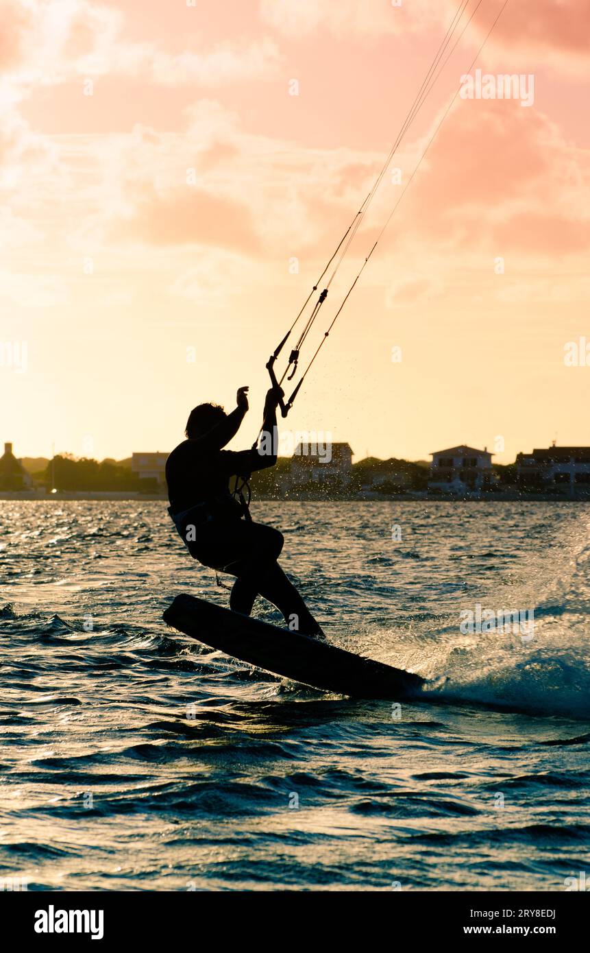 Silhouette d'un kitesurfer volant Banque D'Images
