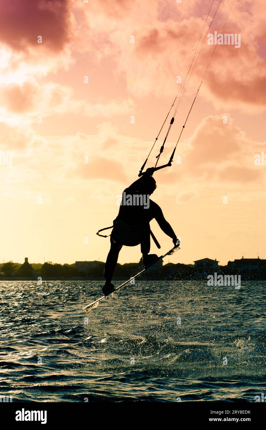 Silhouette d'un kitesurfer volant Banque D'Images