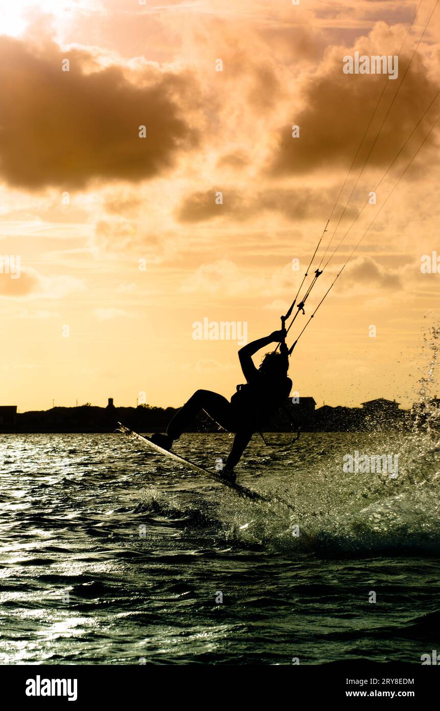 Silhouette d'un kitesurfer volant Banque D'Images