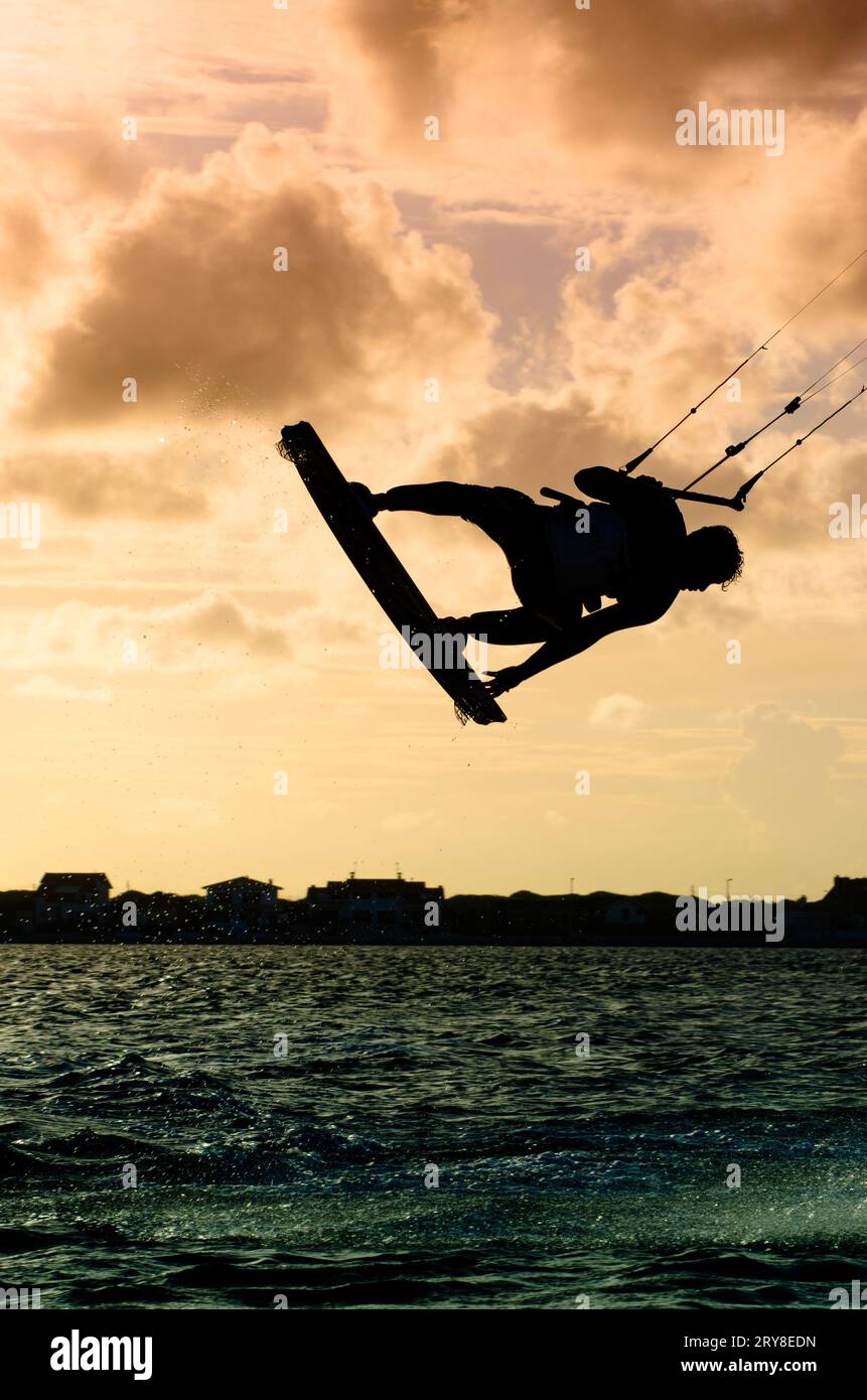 Silhouette d'un kitesurfer volant Banque D'Images