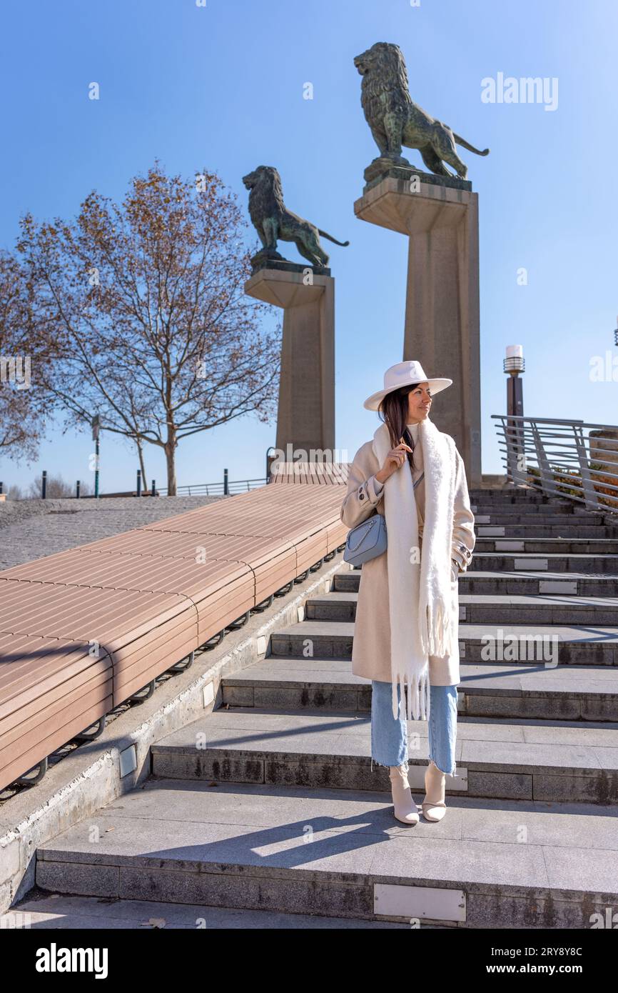 Jeune femme au manteau blanc marchant sur le pont de pierre à Saragosse Banque D'Images
