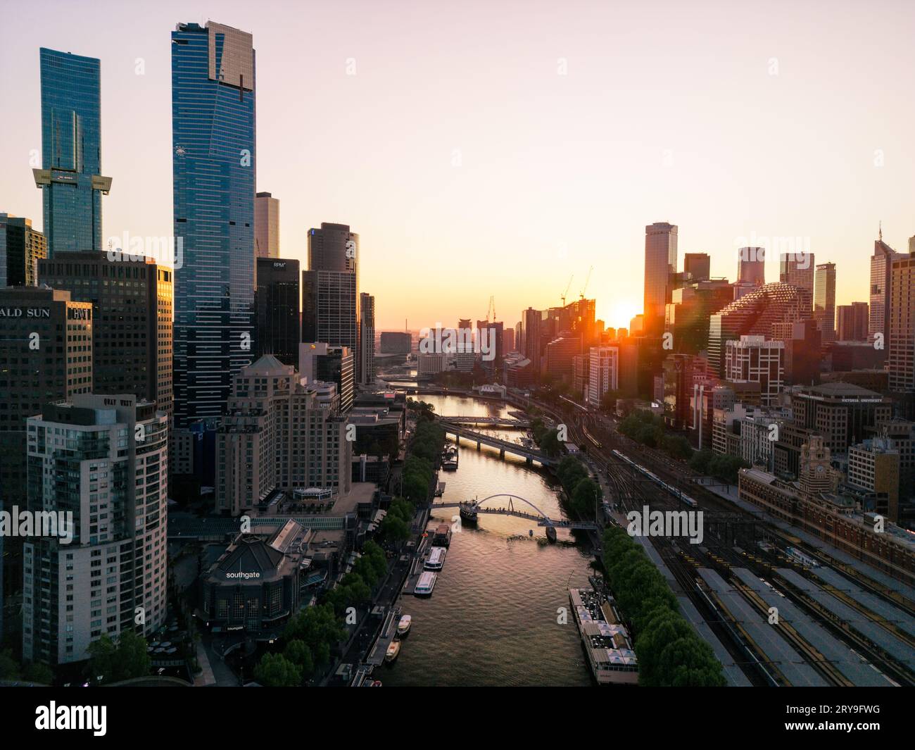 Une vue sur la rivière Yarra flanquait mes grands buidlings de la ville, des bateaux amarrés sur les rives et des ponts de promenade pris au coucher du soleil à Melbourne, en Australie. Banque D'Images