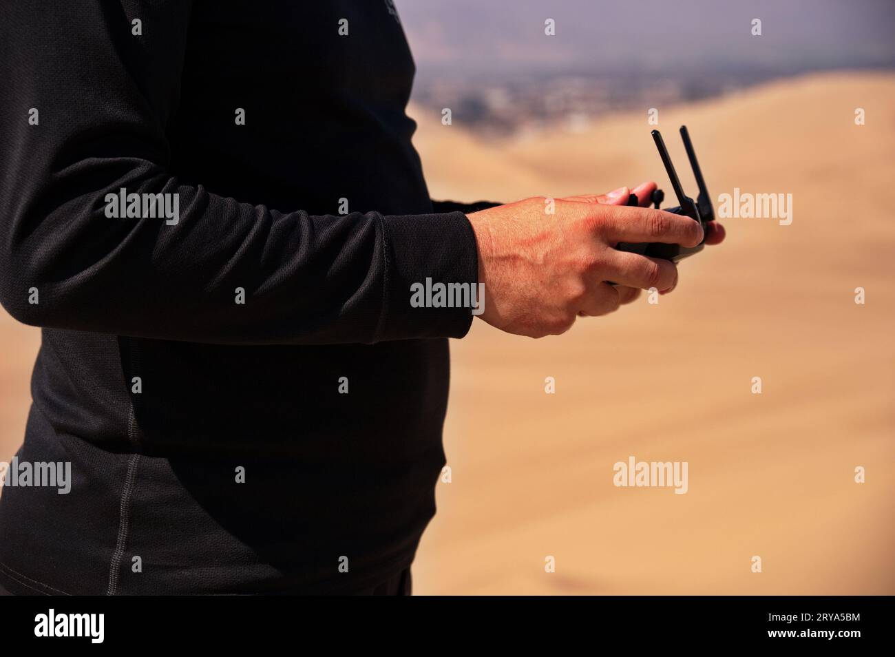 Section médiane des mains de Mans contrôlant drone dans le désert Banque D'Images